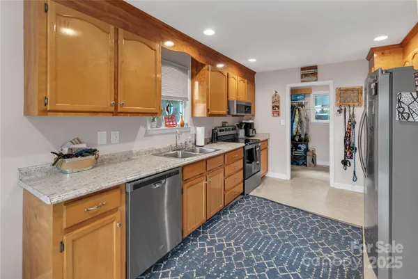 a kitchen with stainless steel appliances granite countertop a sink stove and refrigerator