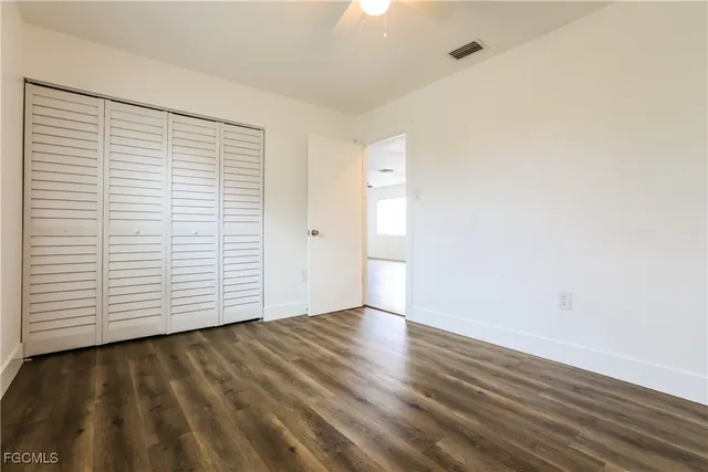 an empty room with wooden floor and white walls