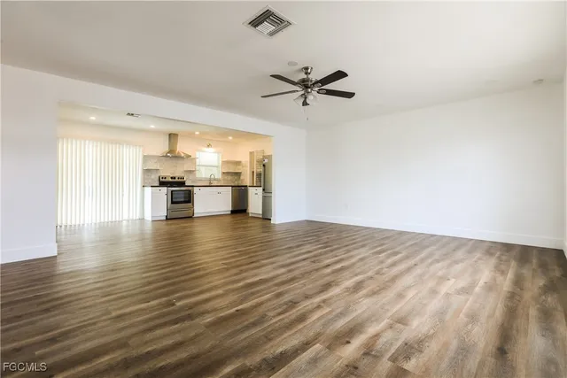 a view of empty room with wooden floor and window
