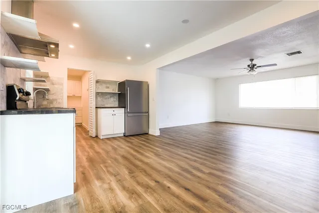 a kitchen with stainless steel appliances a refrigerator and wooden floor