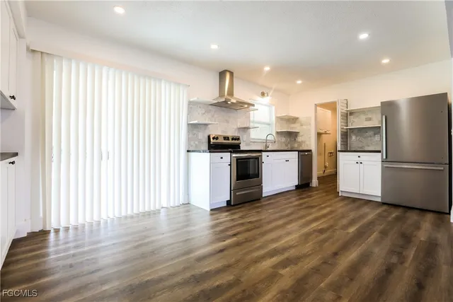 a kitchen with stainless steel appliances granite countertop a refrigerator and a stove top oven