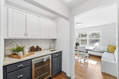 a kitchen with stainless steel appliances granite countertop a stove a sink and white cabinets with wooden floor