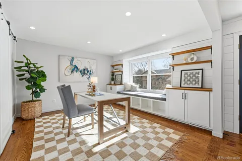 a living room with stainless steel appliances kitchen island granite countertop furniture a rug and a window