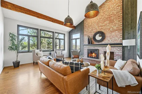 a living room with furniture a fireplace and a floor to ceiling window