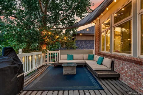 a balcony with couches and a potted plant on a table