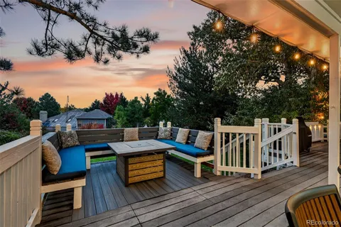 a wooden deck with couches and wooden fence