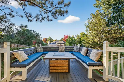 a view of a deck with couches table and chairs with wooden floor and fence