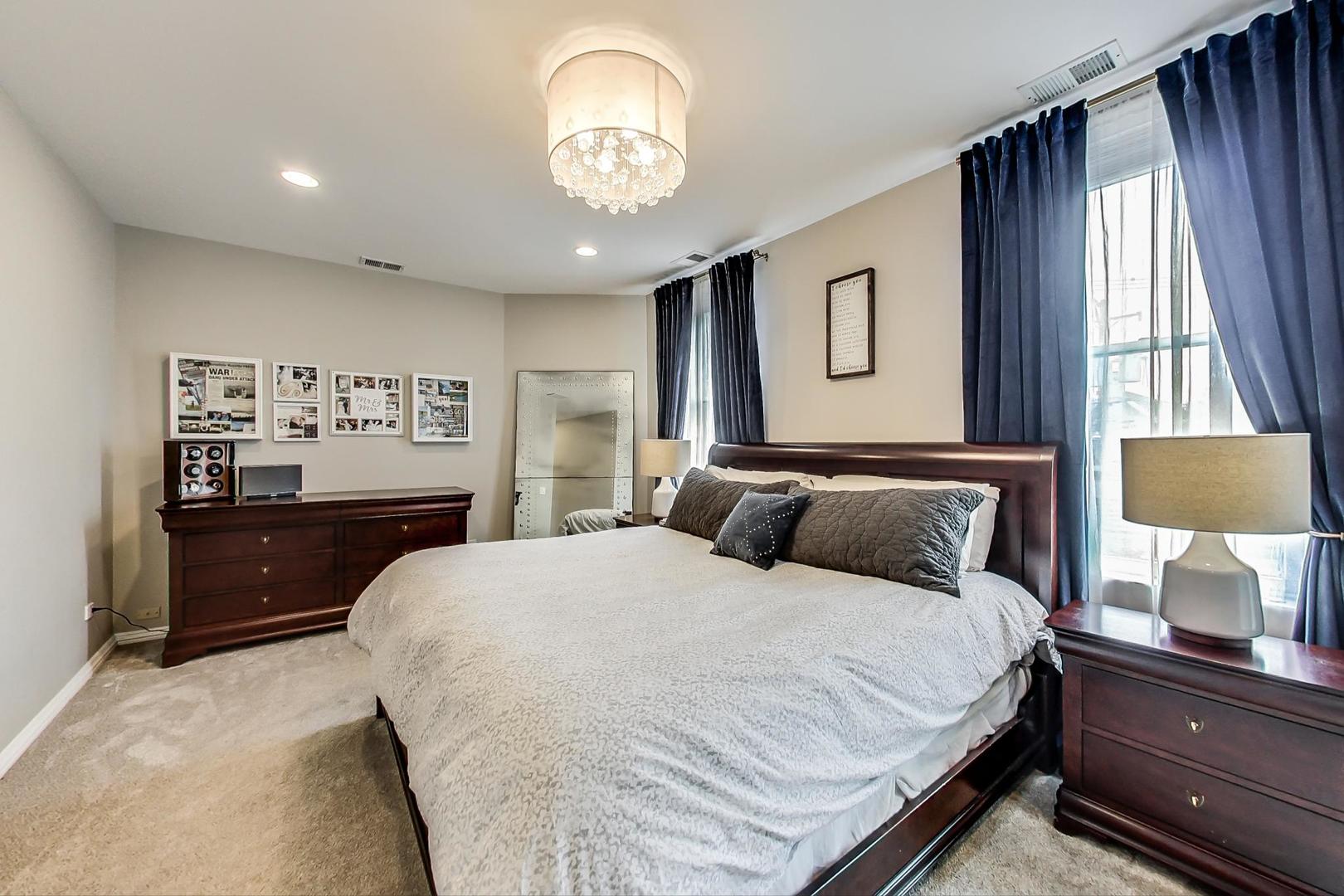 2630 North Racine Avenue Chicago, IL 60614 - Photo 21 of 47 a bedroom with a large bed and a chandelier