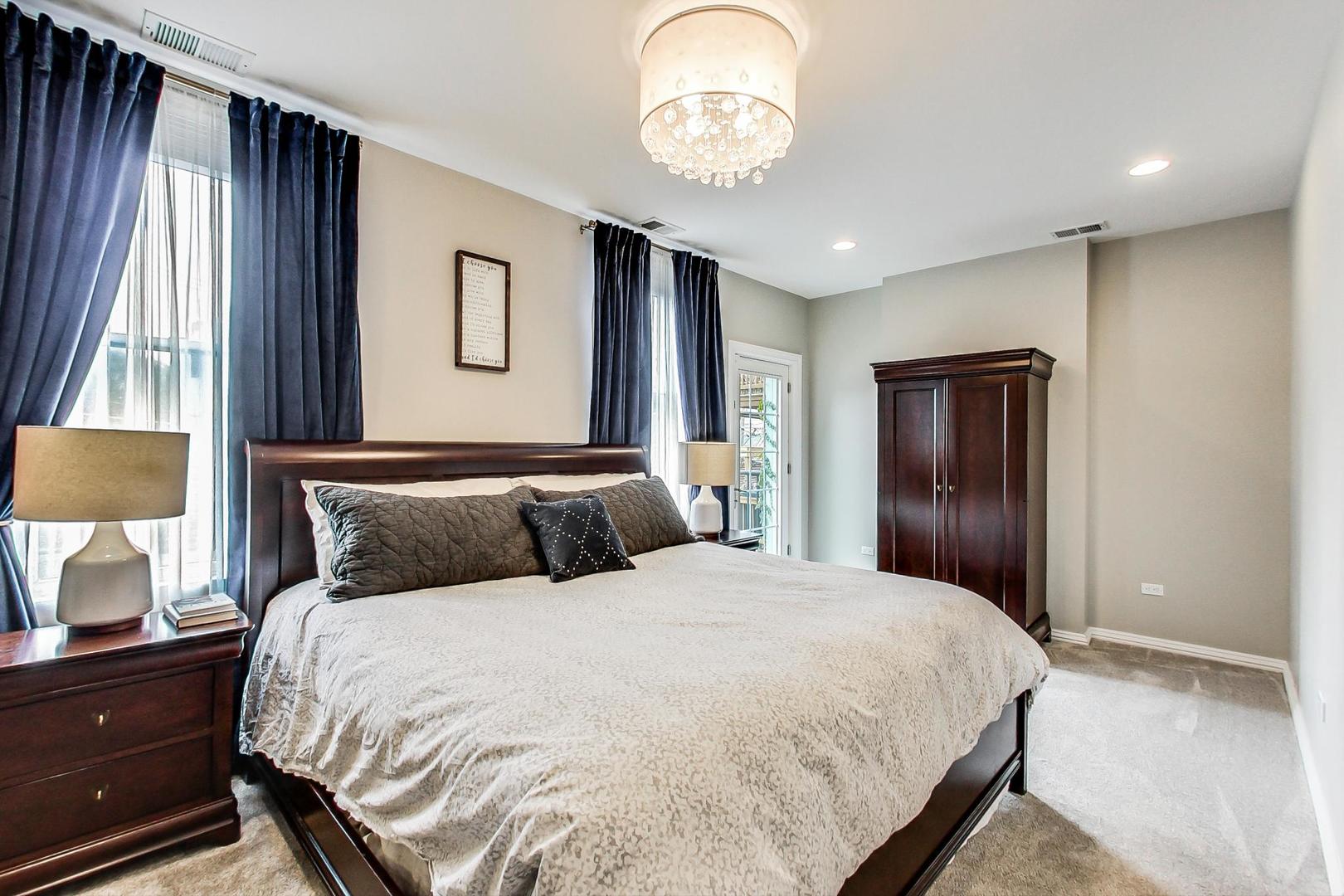2630 North Racine Avenue Chicago, IL 60614 - Photo 22 of 47 a bedroom with a large bed and a chandelier