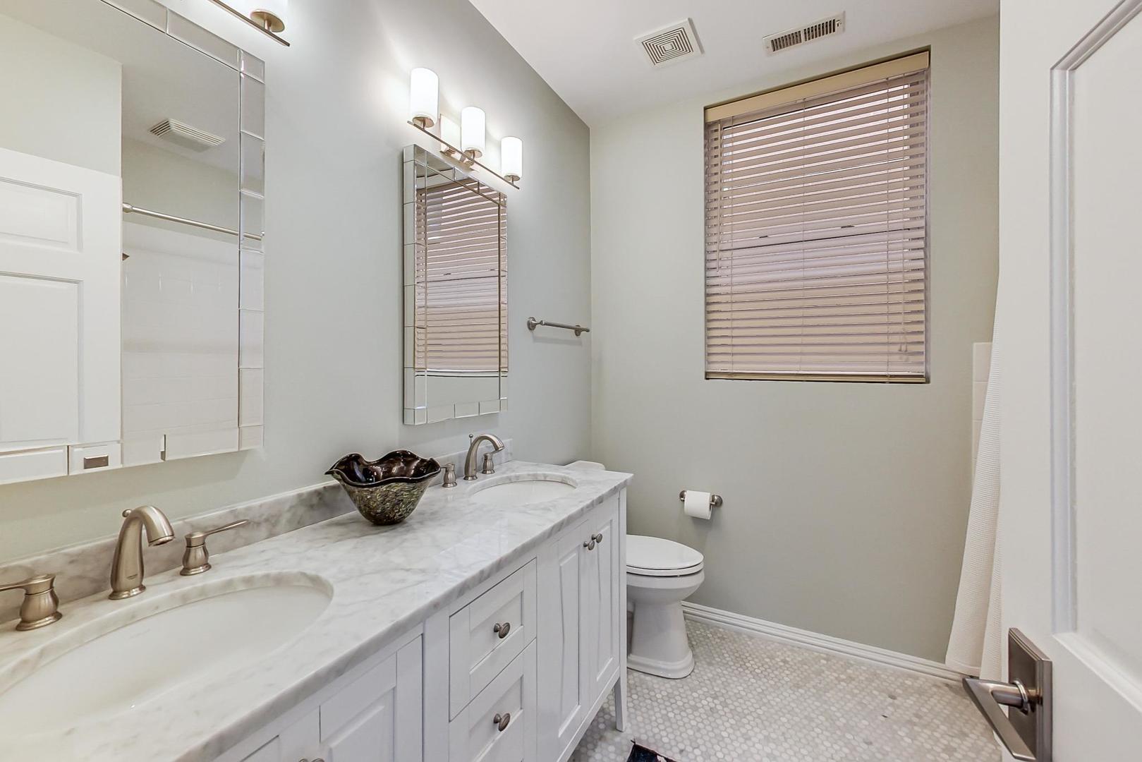 2630 North Racine Avenue Chicago, IL 60614 - Photo 30 of 47 a bathroom with a double vanity sink a toilet and a mirror