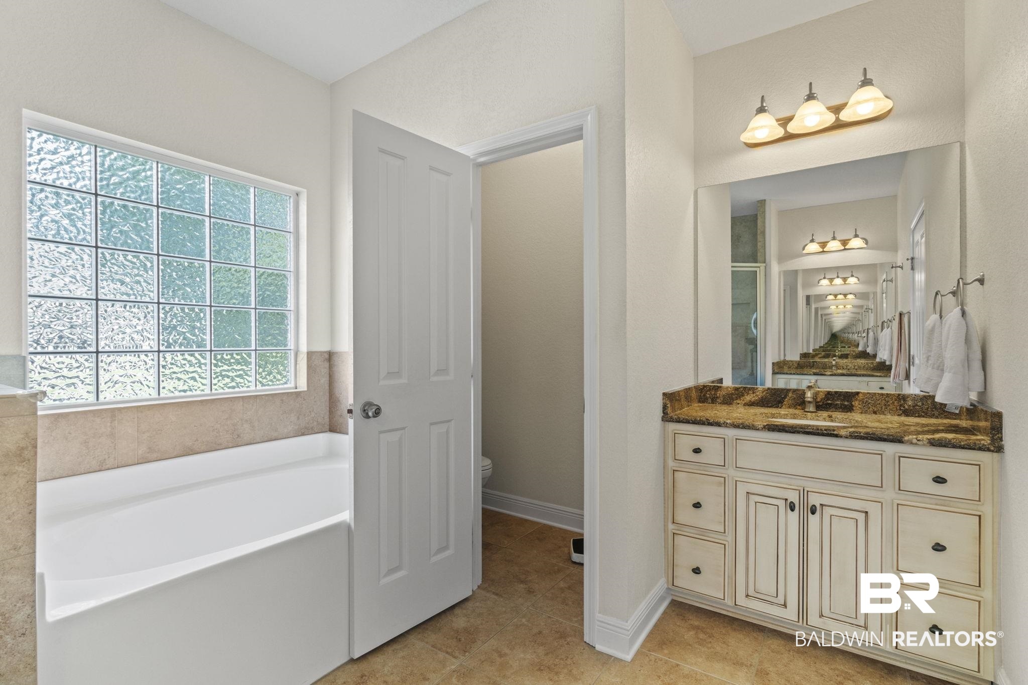 8664 Foxtail Loop Pensacola, FL 32526 - Photo 39 of 64 Bathroom with toilet, tile patterned floors, a garden tub, vanity, and baseboards