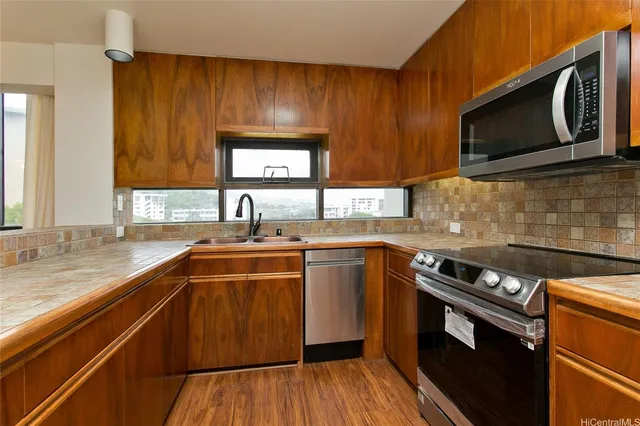 a kitchen with stainless steel appliances wooden cabinets stove and microwave