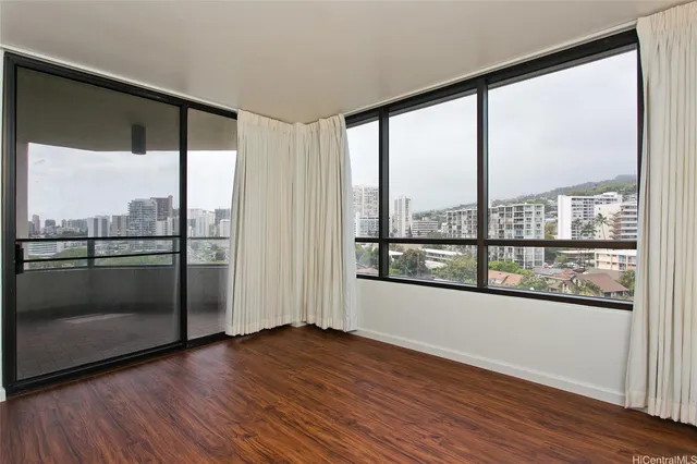 a view of a big room with wooden floor and windows