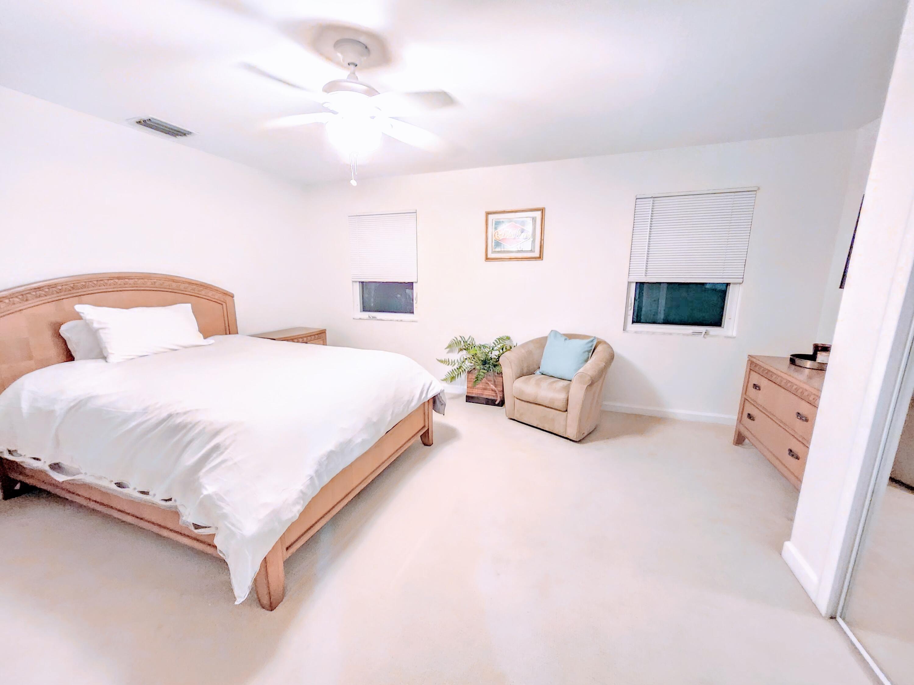 3567 Commodore Circle Delray Beach, FL 33483 - Photo 42 of 76 a spacious bedroom with a bed and a couch