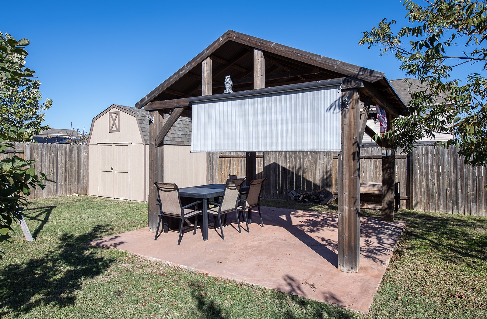 216 Millers Loop Jarrell, TX 76537 - Photo 24 of 31 Fenced backyard with a patio area with awnings pulled down and a storage shed