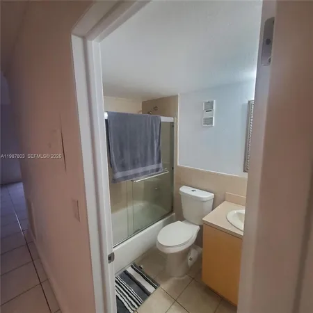 a white toilet sitting next to a shower