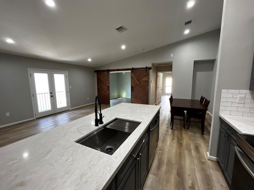 2425 Augusta Drive, Unit 44 Houston, TX 77057 - Photo 2 of 16 a kitchen with stainless steel appliances granite countertop a sink a stove and a wooden floors