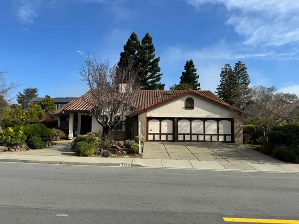 a view of a house with a yard and potted plants