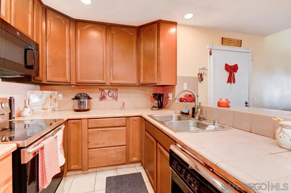 3550 Ruffin Road, Unit 261 San Diego, CA 92123 - Photo 10 of 22 a kitchen with stainless steel appliances a sink dishwasher and cabinets with wooden floor