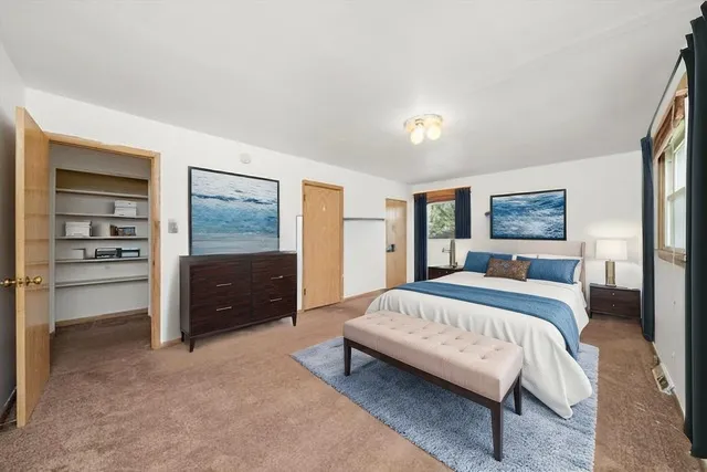 a spacious bedroom with a bed and a cabinets