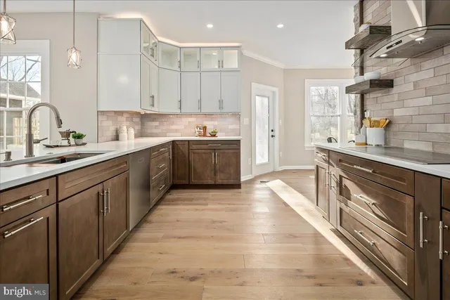 a view of a hallway with wooden floor and a bathroom