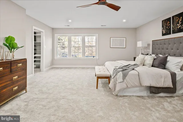 a living room with furniture a large window and wooden floor