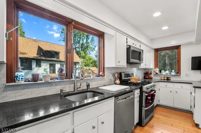a dining room with furniture potted plants and wooden floor