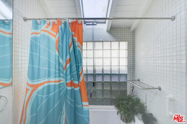 a bedroom with a bed table and a large mirror