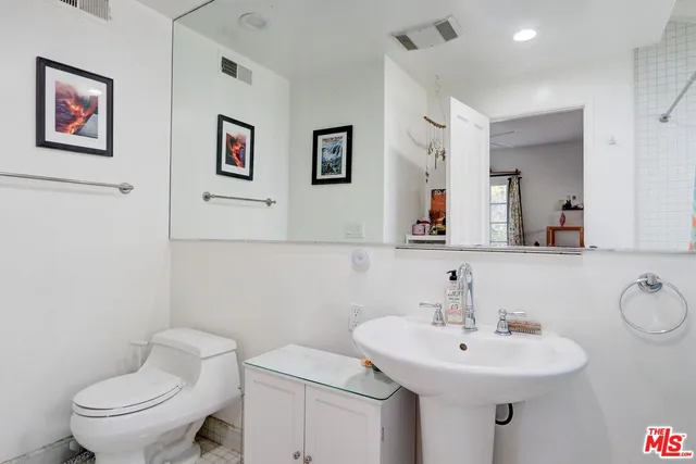 a bathroom with a toilet sink a window and mirror