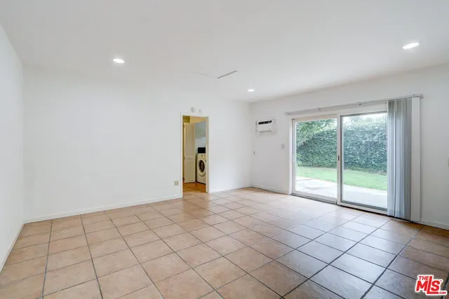 a view of a house with a large window and plants