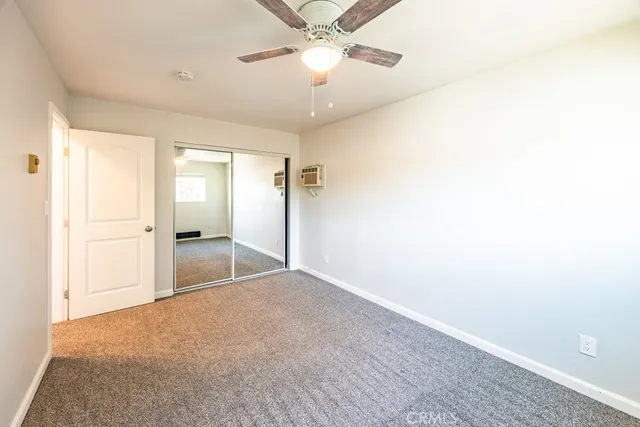 a view of a room with a ceiling fan and a bathroom
