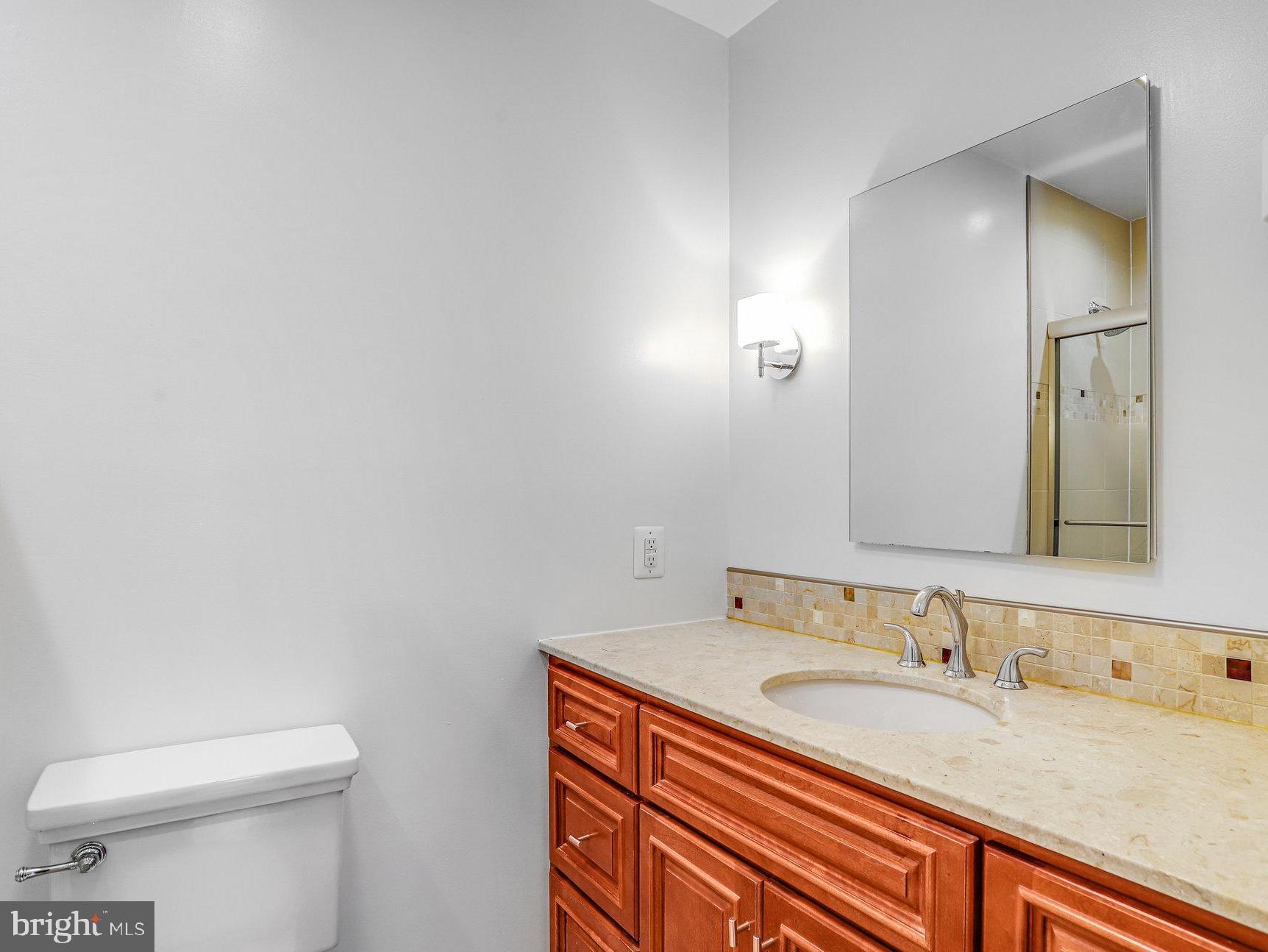 3275 Sutton Place Northwest, Unit A Washington, DC 20016 - Photo 18 of 27 a bathroom with a granite countertop sink and a mirror