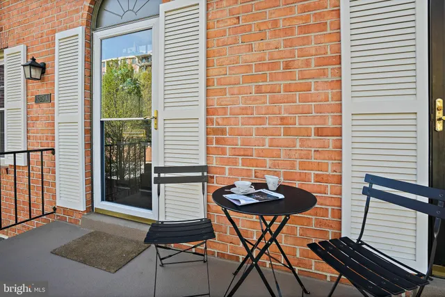 a view of a brick wall with a chair and a potted plant