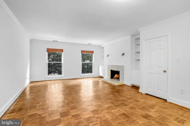 a view of an empty room with a fireplace and window