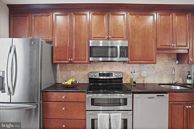 a kitchen with stainless steel appliances granite countertop a refrigerator microwave and sink