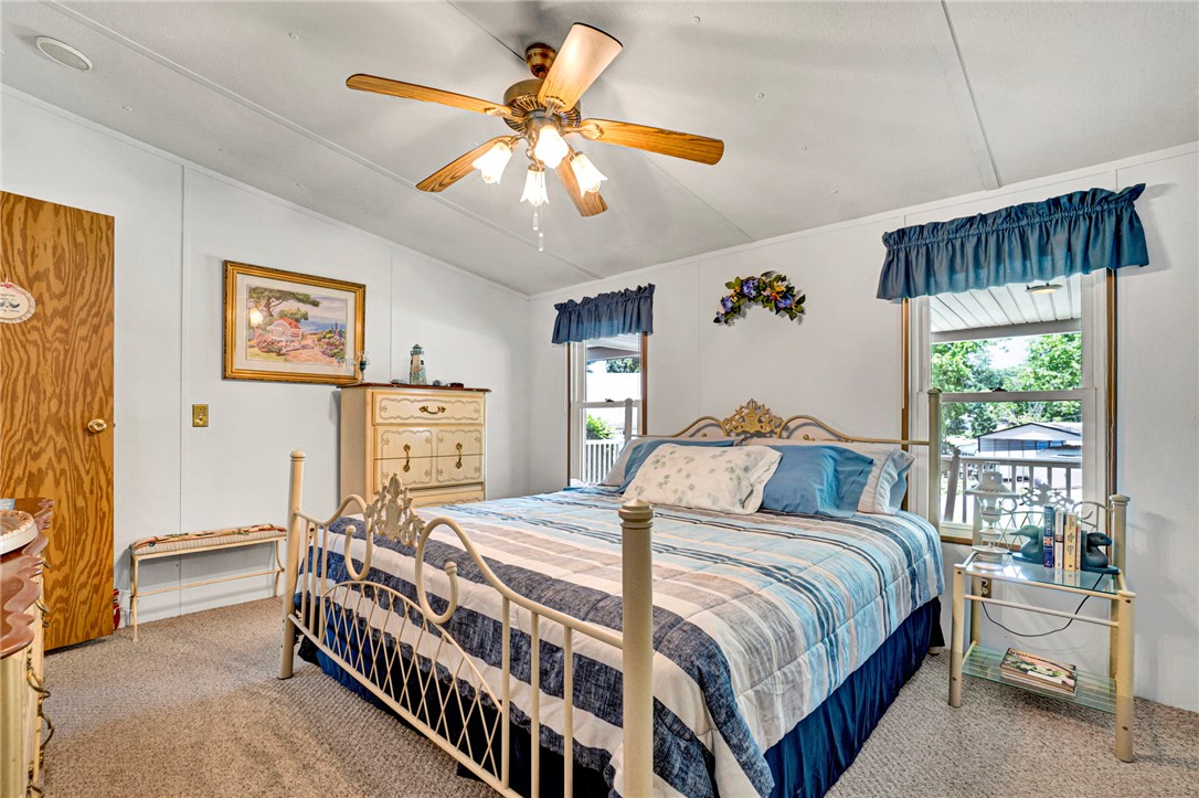 225 Nicholson Cove Road Seneca, SC 29672 - Photo 16 of 22 Comfortable bedroom with a traditional aesthetic, featuring a ceiling fan and natural lighting from the outdoor view.