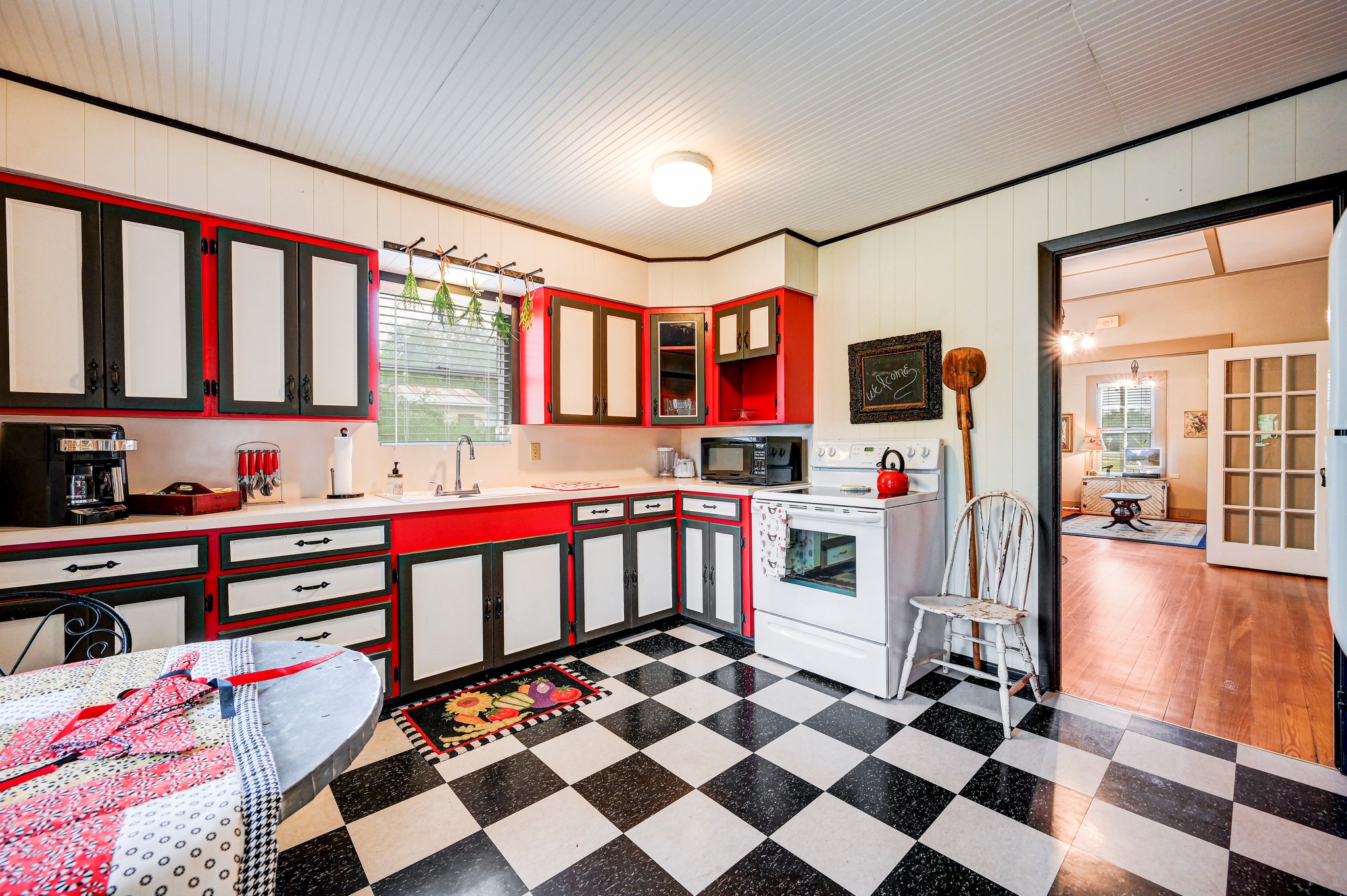 719 Elm Street Blanco, TX 78606 - Photo 12 of 25 Kitchen featuring checkerboard flooring, red and black cabinetry, white countertops, and a full-size white range
