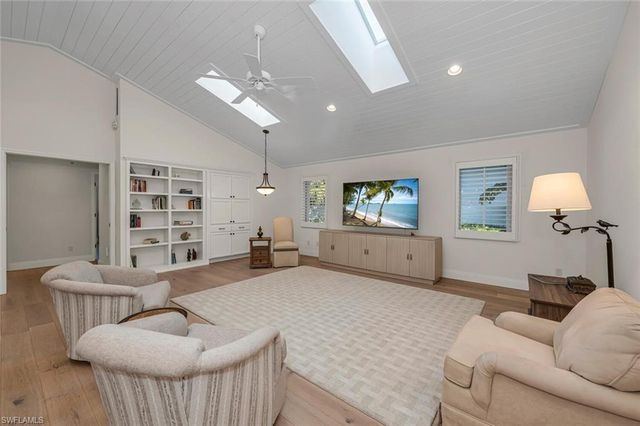 a spacious bedroom with a bed couch and window