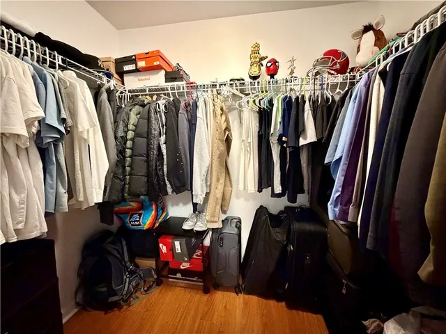 a view of walk in closet with clothes and shoes
