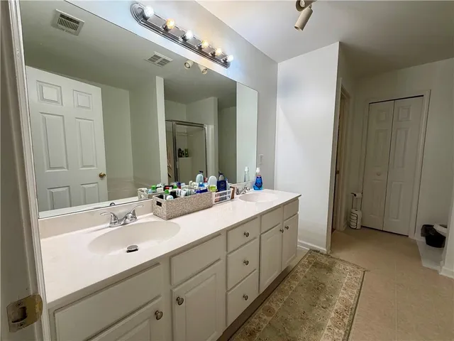 a spacious bathroom with a double vanity sink and a mirror