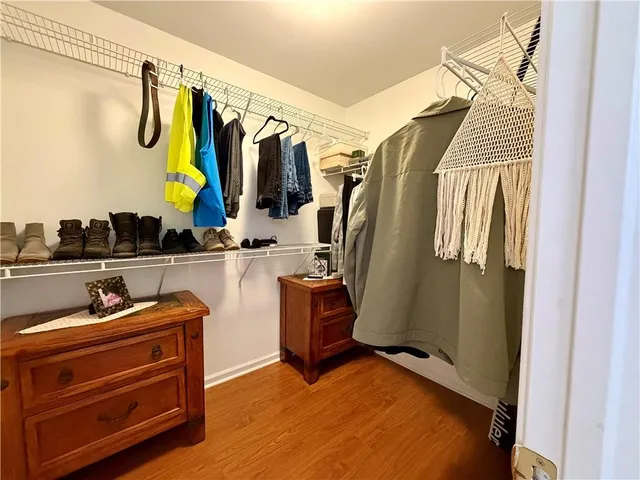 a view of walk in closet with clothes and shoes