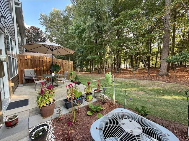 a view of a table and chairs in backyard of the house
