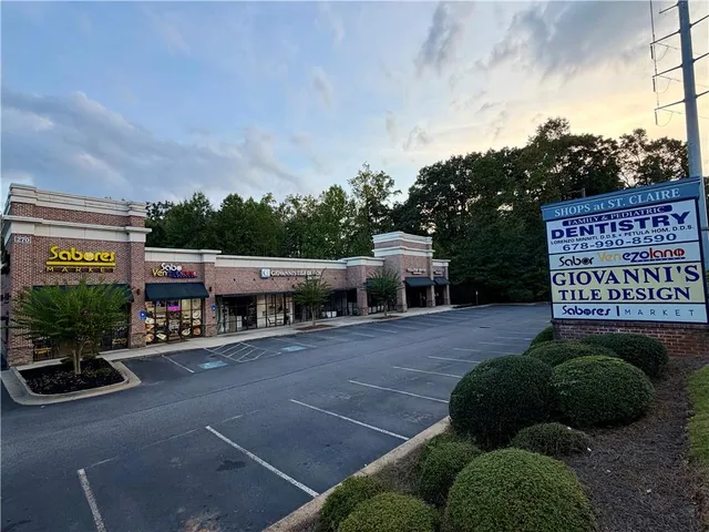 a view of a street with potted plants and a bench
