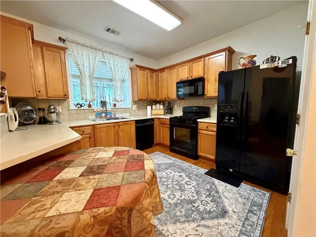 a kitchen with stainless steel appliances kitchen island granite countertop a refrigerator stove top oven and sink
