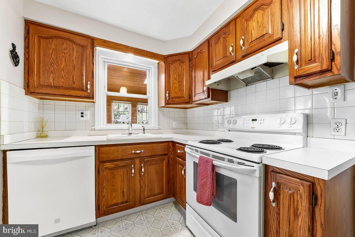 428 Wheatsheaf Road Springfield, PA 19064 - Photo 19 of 40 a kitchen with stainless steel appliances granite countertop a sink stove and cabinets
