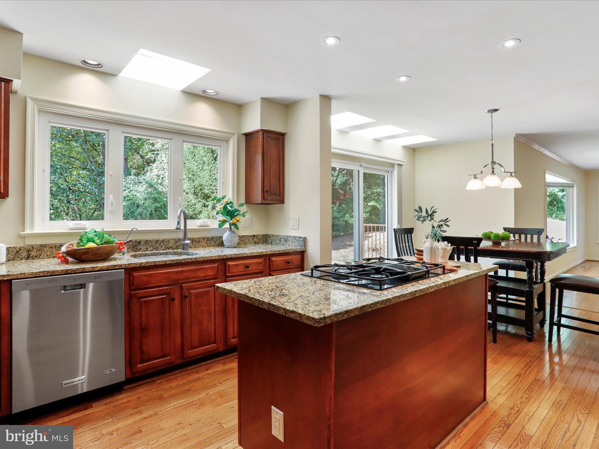 1350 Hunter Mill Road Reston, VA 20190 - Photo 13 of 75 a kitchen with kitchen island granite countertop wooden cabinets and a large window