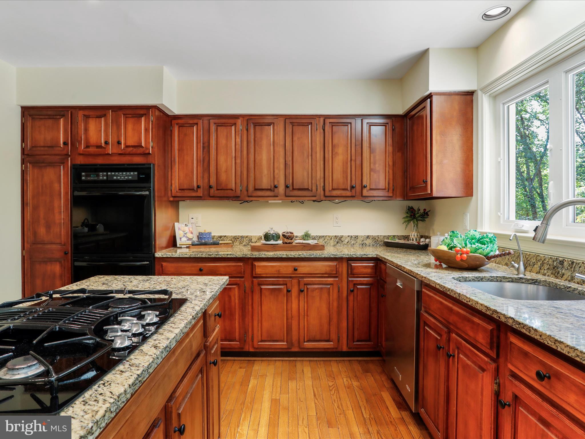 1350 Hunter Mill Road Reston, VA 20190 - Photo 15 of 75 a kitchen with granite countertop wooden cabinets and a stove top oven