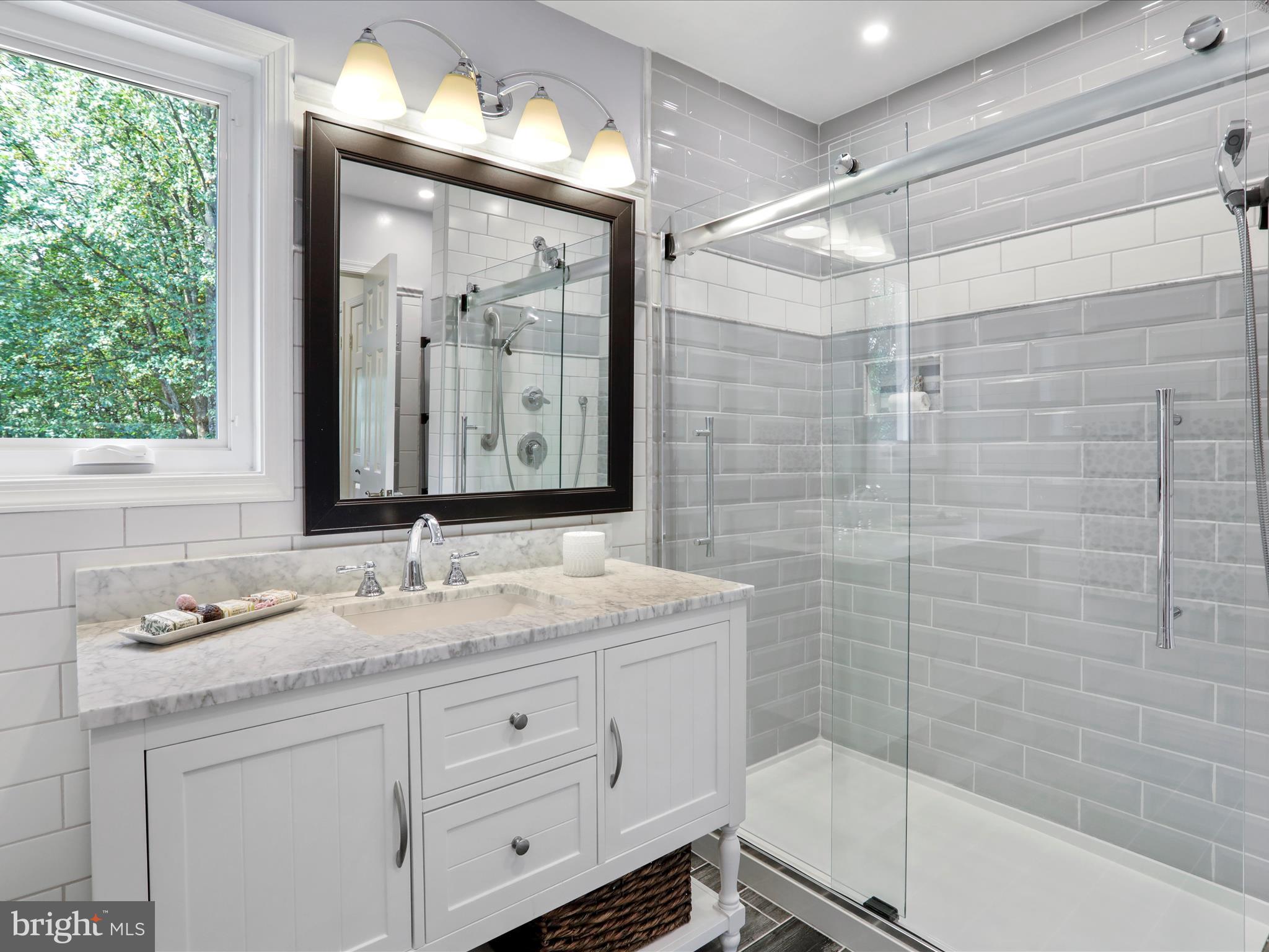 1350 Hunter Mill Road Reston, VA 20190 - Photo 37 of 75 a bathroom with a granite countertop sink a mirror a bathtub and shower