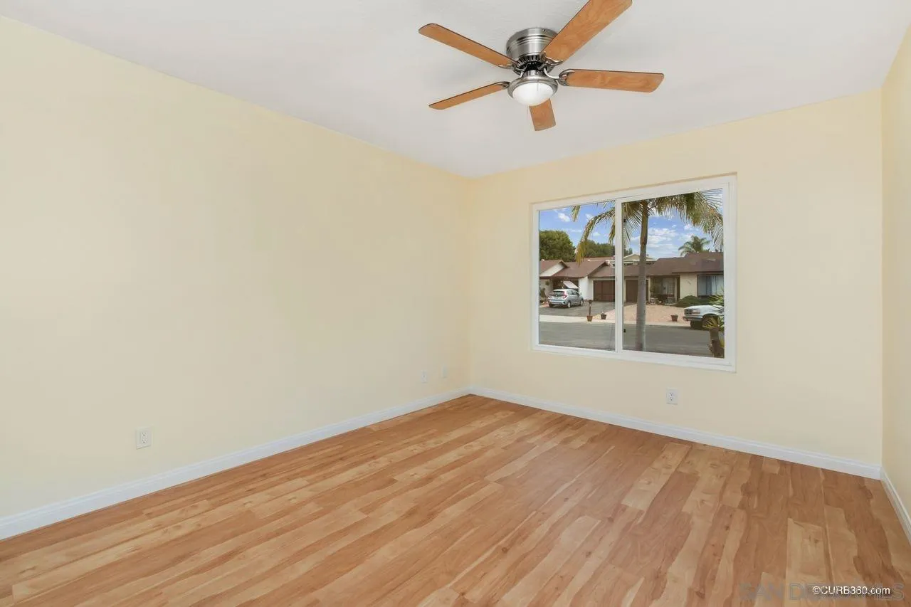 1427 Panorama Ridge Road Oceanside, CA 92056 - Photo 24 of 33 an empty room with wooden floor ceiling fan and windows