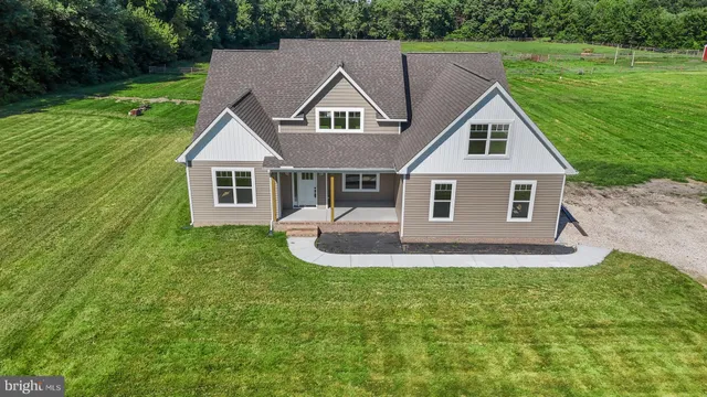 a aerial view of a house next to a big yard and large trees